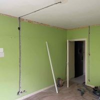 Villanyszerelő vezetékáthúzás közben régi lakás felújításakor